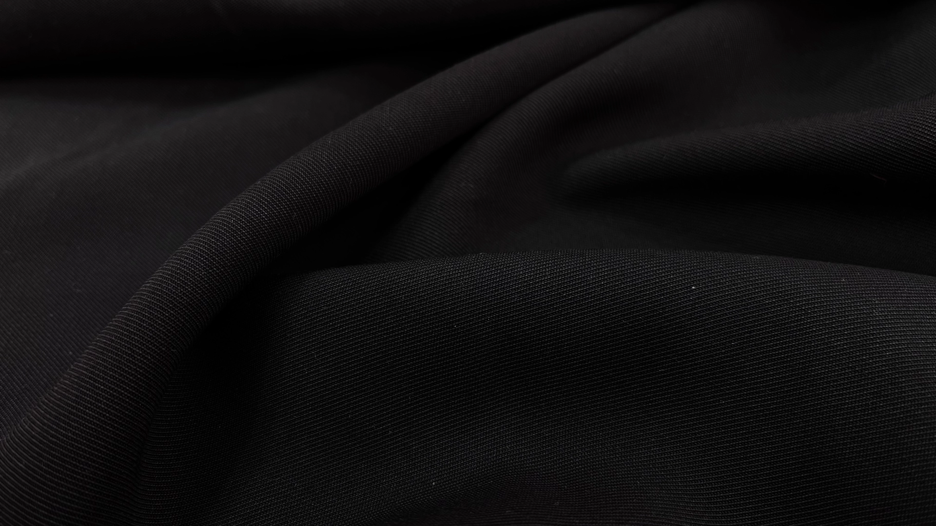 Костюмная ткань с диагональной выработкой черного цвета. За счет нейлона в составе держит форму, хорошо струится. Подойдет для пошива брюк со стрелкой, жакета или юбки "по-косой".