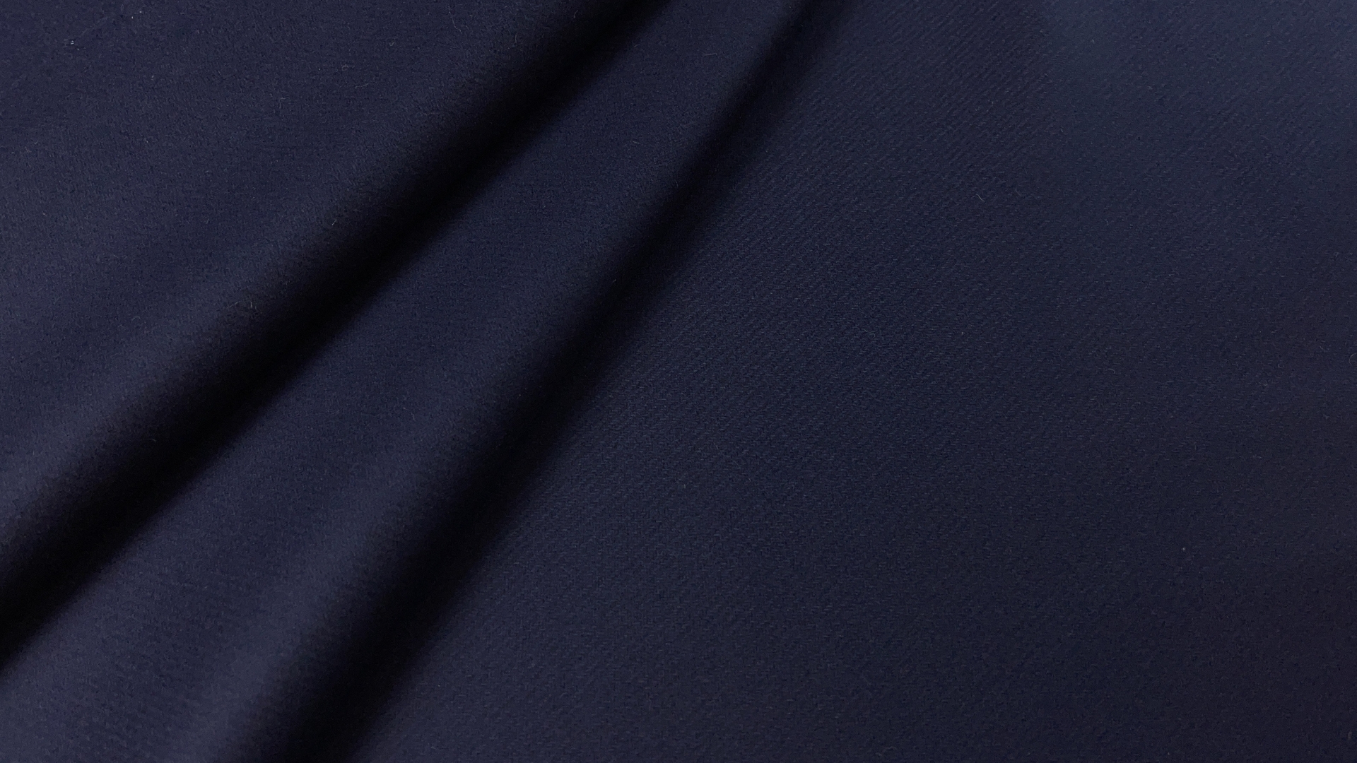 Темно-синяя пальтовая ткань с красивым лоском. Имеет не ярко выраженную диагональную выработку. Полотно двустороннее, но не двуслойное. Для пошива изделия без подклада швы необходимо закрывать кантом. Идеально для пошива строгих прямых изделий или полуприлегающего силуэта.