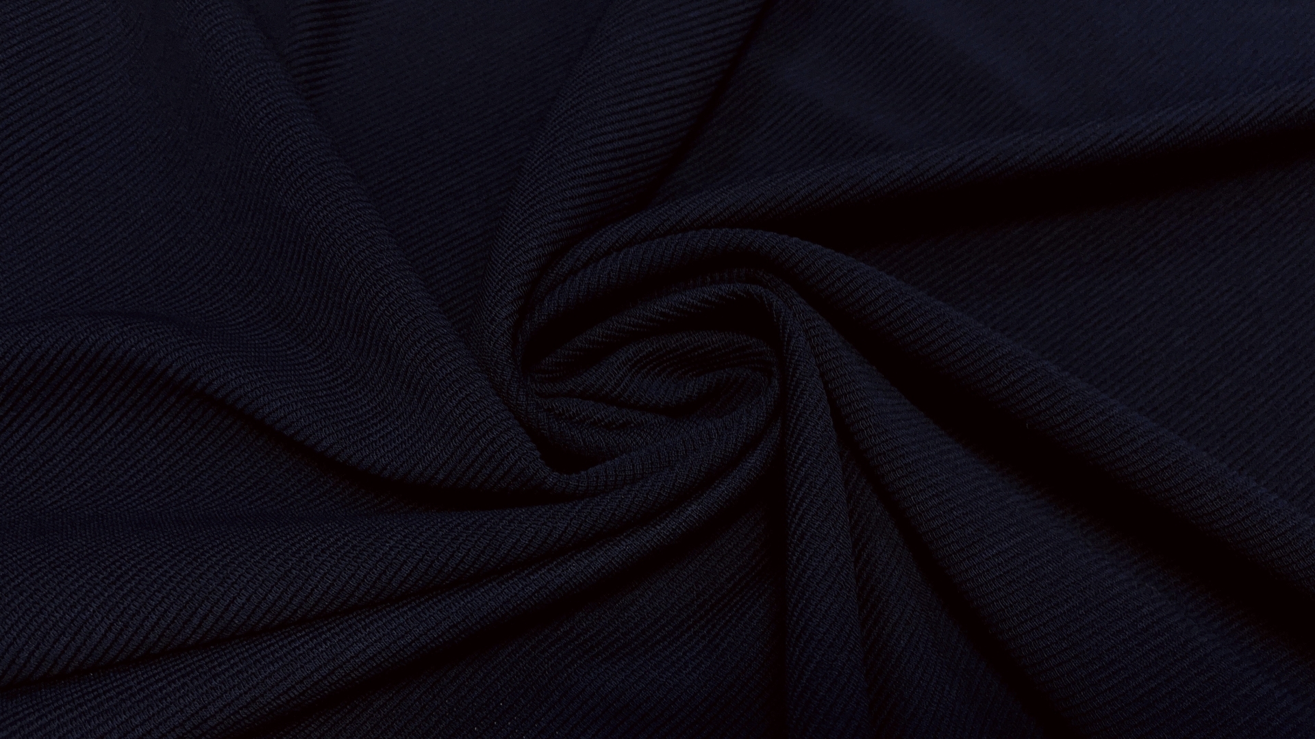 Темно-синий вискозный трикотаж в поперечный рубчик с добавлением полиэстера. Подходит для пошива водолазок, платьев или брючных спортивных костюмов с бомбером.