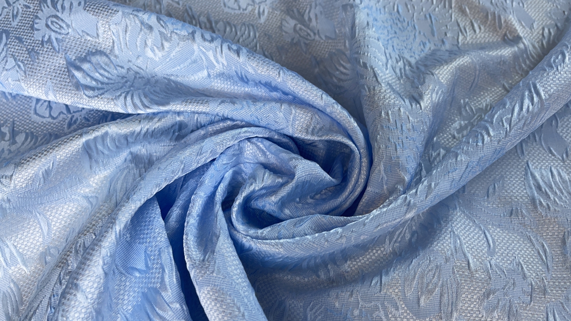 Жаккард с объемными цветами нежно-голубого цвета. Подойдет для пошива платья, пышной юбки, жакета или легкого летне-весеннего пальто.
