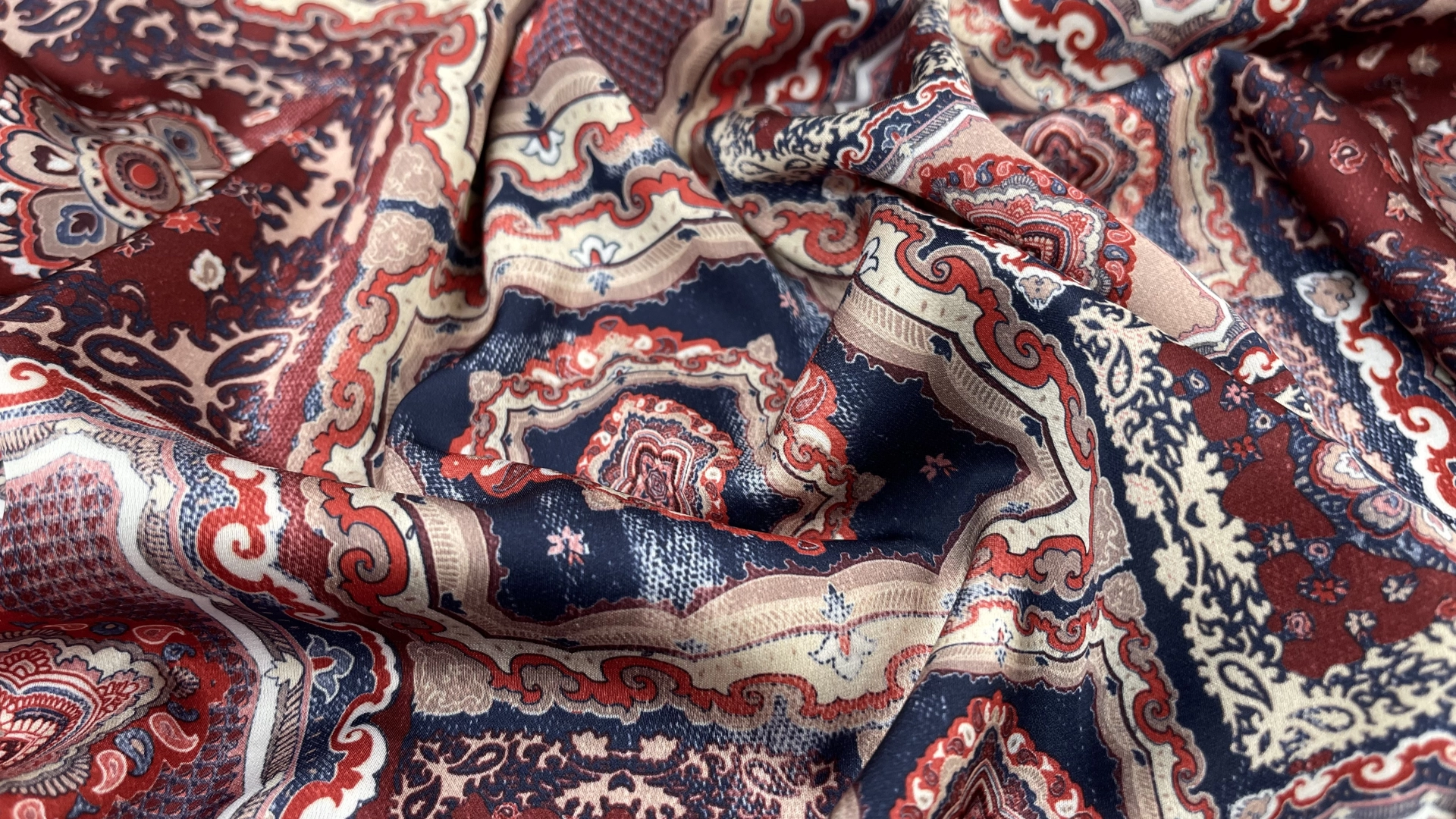 Атлас с торговым названием Армани с принтом в стиле печворк. Сочетание красно-бордовых оттенков с темно-синими. Тактильно атлас очень приятный, мягкий и струящийся. Идеален для пошива рубашки или платья.