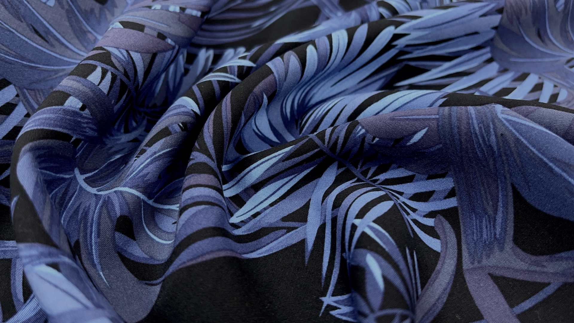 Штапель черного цвета с крупными ярко-синими листьями. Тонкое полотно с идеальным плетением. За счет натурального состава ткань идеально подходит для пошива летних изделий. В них тело будет "дышать". Универсальность ткани позволяет пошить различные изделия, такие как рубашка, сарафан, комбинезон, платье-рубашка, топ с юбкой, свободные брюки.
