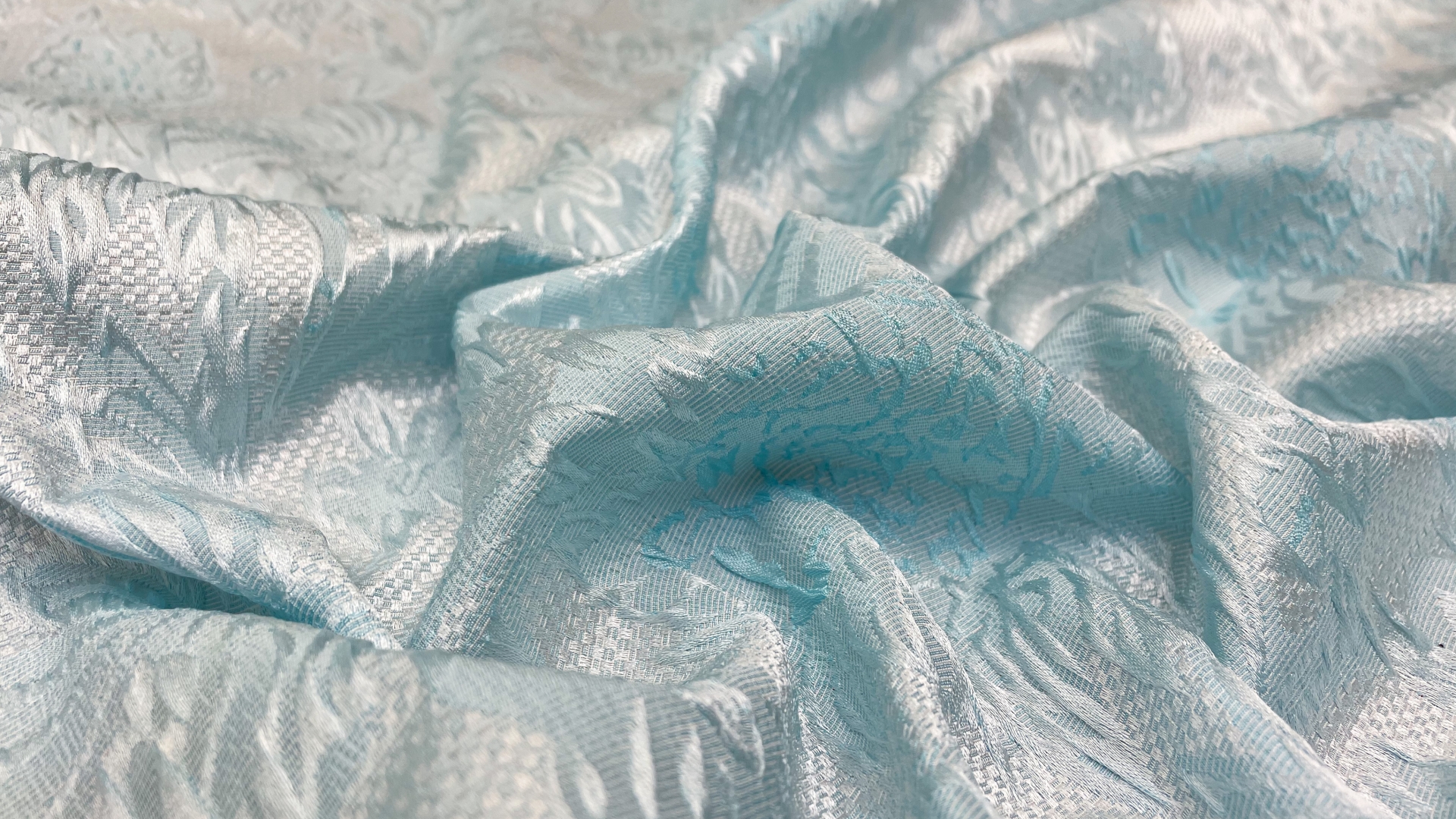 Жаккард с объемными цветами мятно-голубого цвета. Подойдет для пошива платья, пышной юбки, жакета или легкого летне-весеннего пальто.